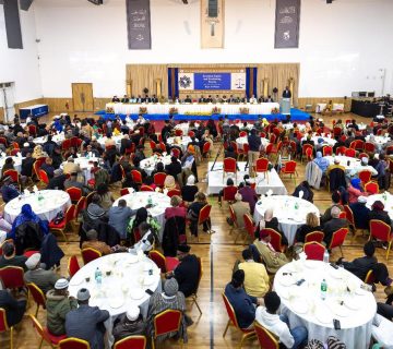 A group of people sitting at tables in a room Description automatically generated